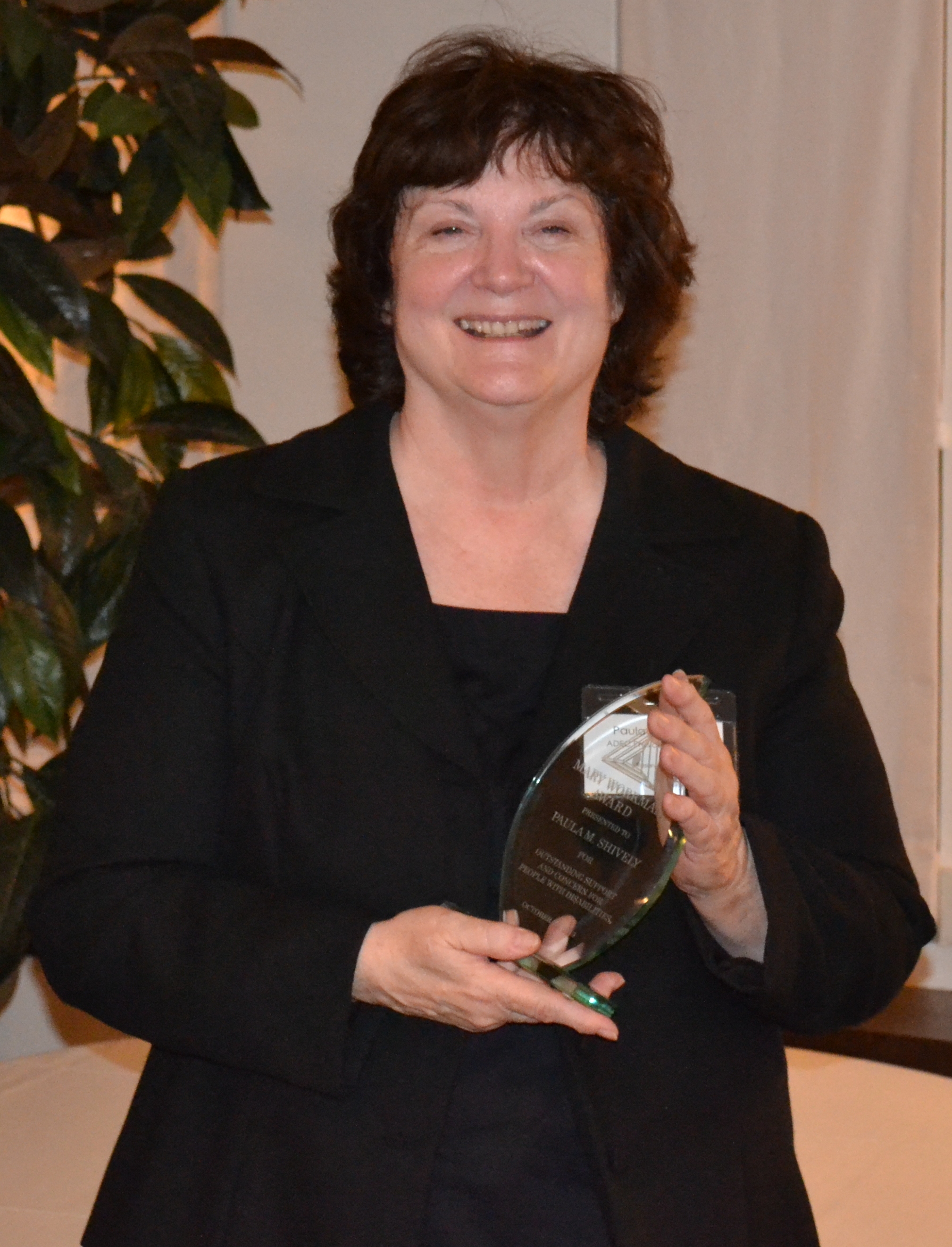 Paula Shively holds The Mary Workman Award, ADEC's highest honor, presented to her Oct. 28, 2013.
