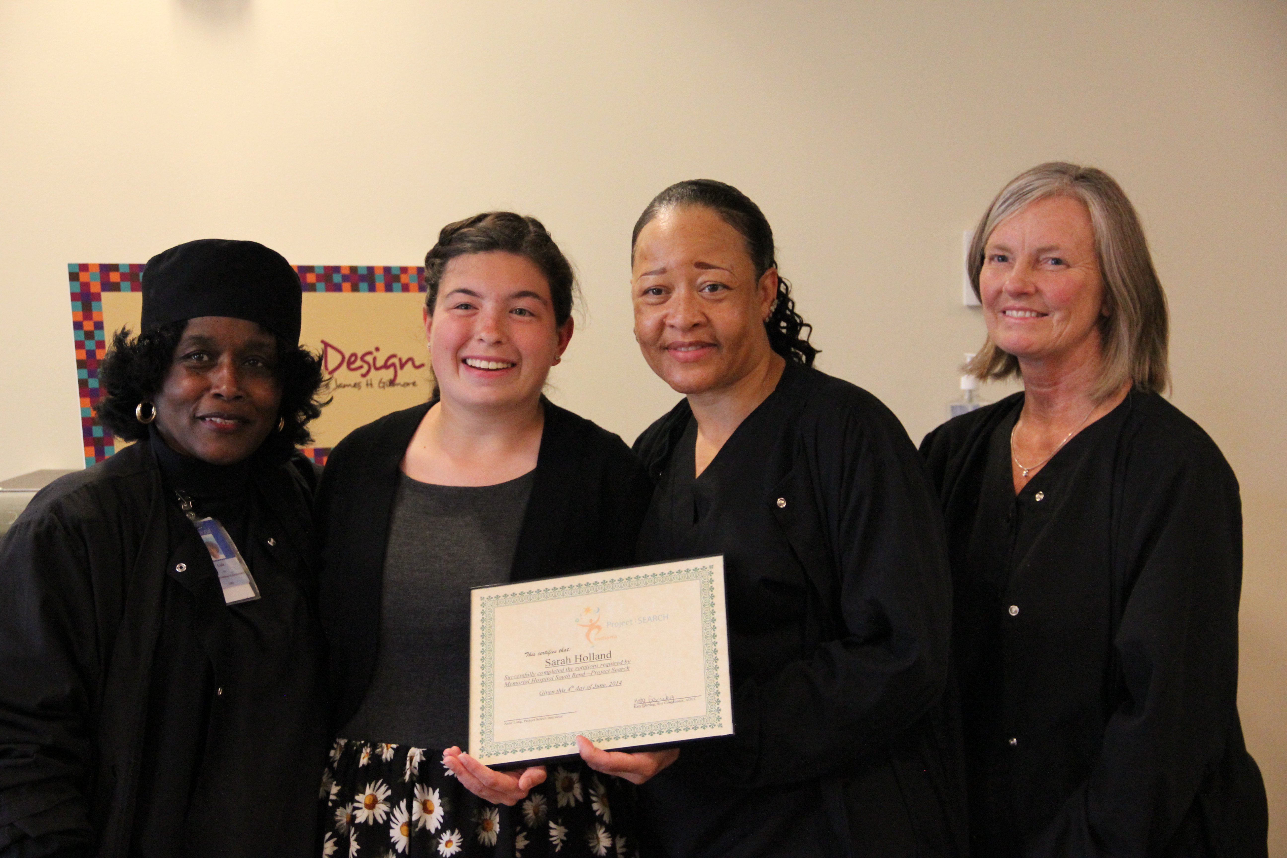 Holding her graduation certificate, Sarah Holland poses for a photo with one of the crews she worked with on a Project Search rotation at Memorial Hospital, South Bend.